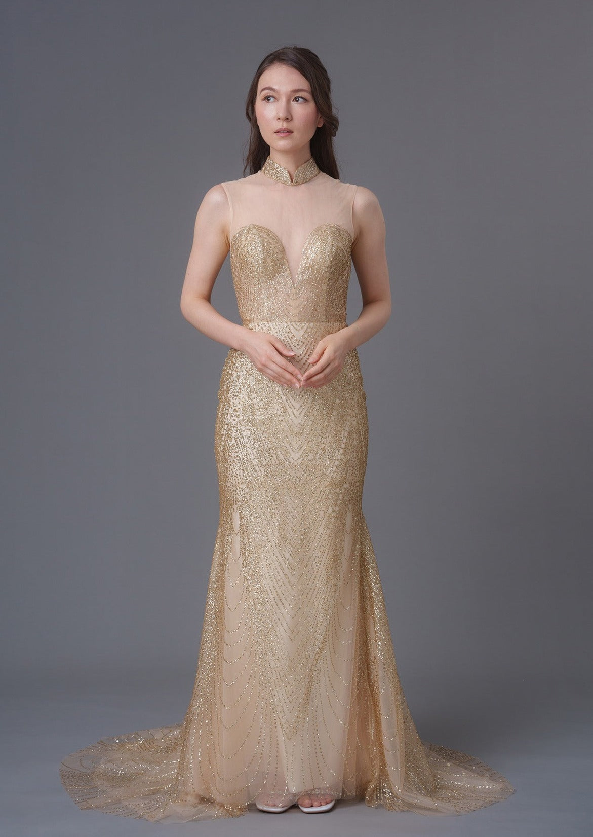 An asian girl in a sleeveless gold sequins mermaid qipao with mesh heart shape bodice. Perfect dress for cocktail parties/ wedding. (full body picture)