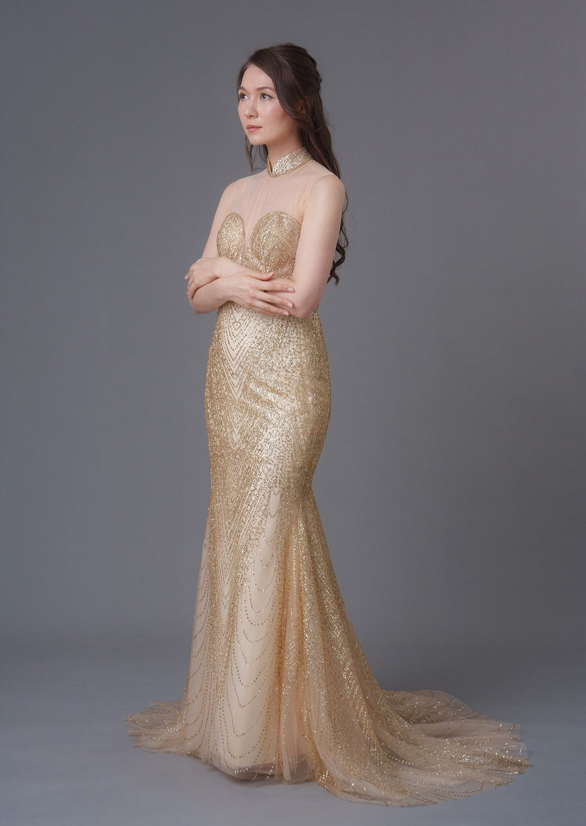 An asian girl in a sleeveless gold sequins mermaid qipao with mesh heart shape bodice. Perfect dress for cocktail parties/ wedding. (Side view picture)