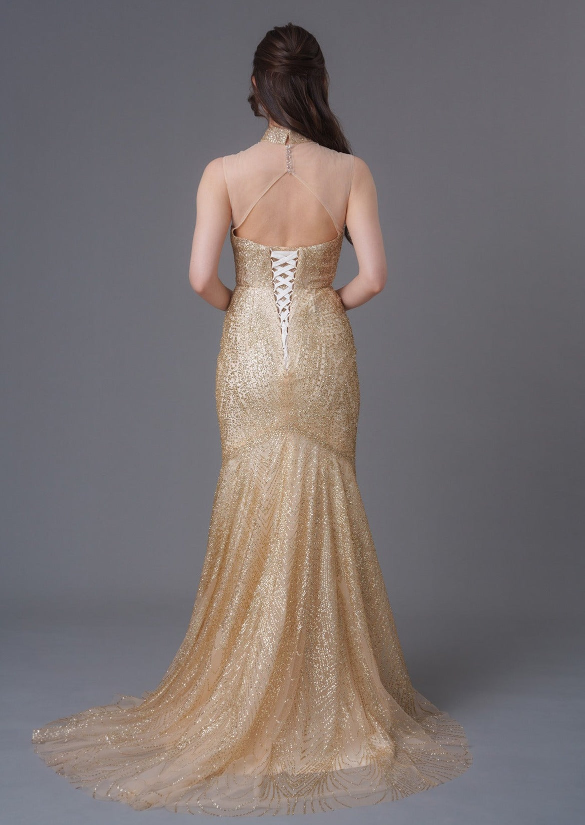 Qipology - An asian girl in a sleeveless gold sequins mermaid qipao with mesh heart shape bodice. Featuring a mandarin collar, open back and lace up details.Perfect dress for cocktail parties/ wedding. (back full body picture)